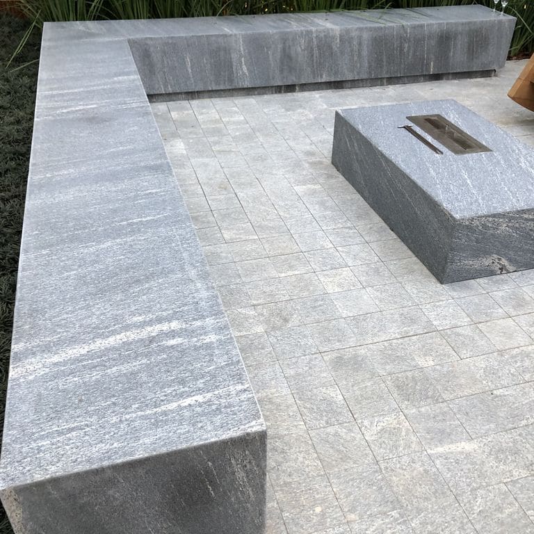 Application image for Brazilian Lucerna Gneiss. The image shows this material being used in a seating &amp; benches application. The surface finish shown is flamed. The dominant color shown is gray. The color mix creates a warm feeling.