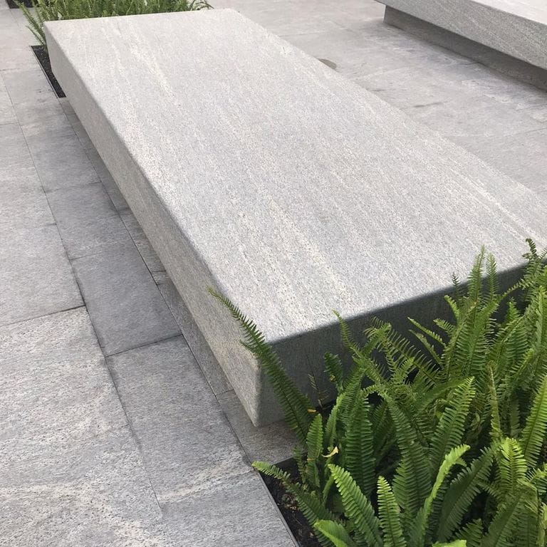 Application image for Brazilian Lucerna Gneiss. The image shows this material being used in a patio pavers application. The surface finish shown is flamed. The dominant color shown is gray. The color mix creates a warm feeling.