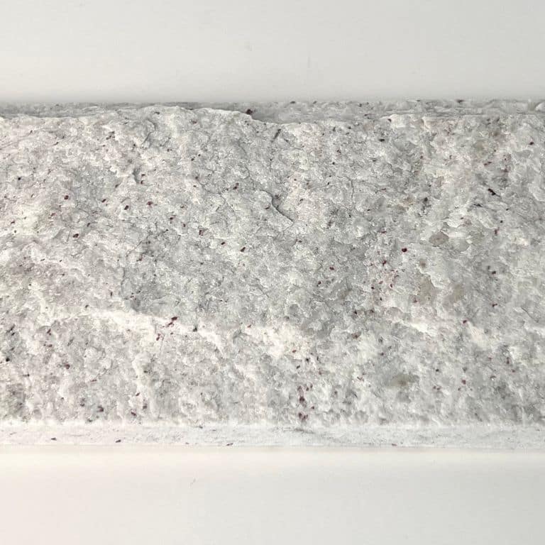 Feature image for Gneiss - Yellow Grumari. The surface finish shown is rockfaced. The dominant color shown is white; with beige, white and cream secondaries. The color mix creates a warm feeling. Fine speckled and cloudy color patterns. Contains some mica and mineral inclusions.