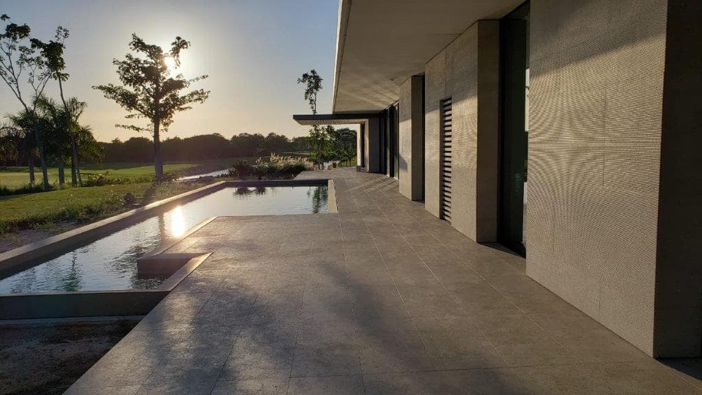 Application image for Veneto Olivo Limestone. The image shows this material being used for pool coping, patio pavers and pool deck pavers. The surface finish shown is flamed. Dominant colors shown are gray and tan. The color mix creates a warm feeling.