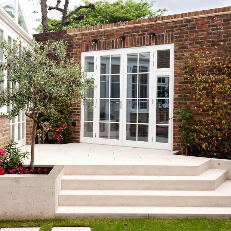 Feature image for Limestone - Veneto Rosato. The image shows this material being used for landscape wallstone, patio pavers and monolithic steps. The surface finish shown is flamed. Dominant colors shown are beige, gray, tan and cream; with brown, orange/rust, pink and white secondaries. The color mix creates a warm feeling. Cloudy color pattern.