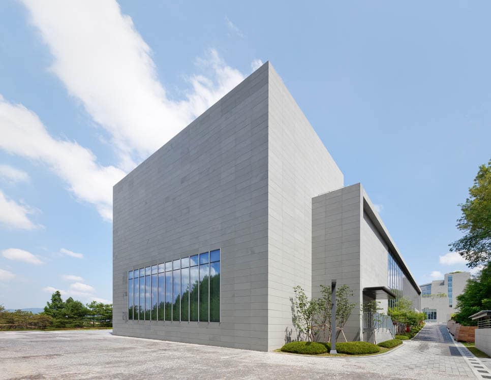 Application image for Pietra Forte Fiorentina Sandstone. The image shows this material being used for patio pavers, full bed veneer and thin veneer. The surface finish shown is honed. Dominant colors shown are blue and gray; with a white secondary. The color mix creates a cool feeling. Solid color pattern.