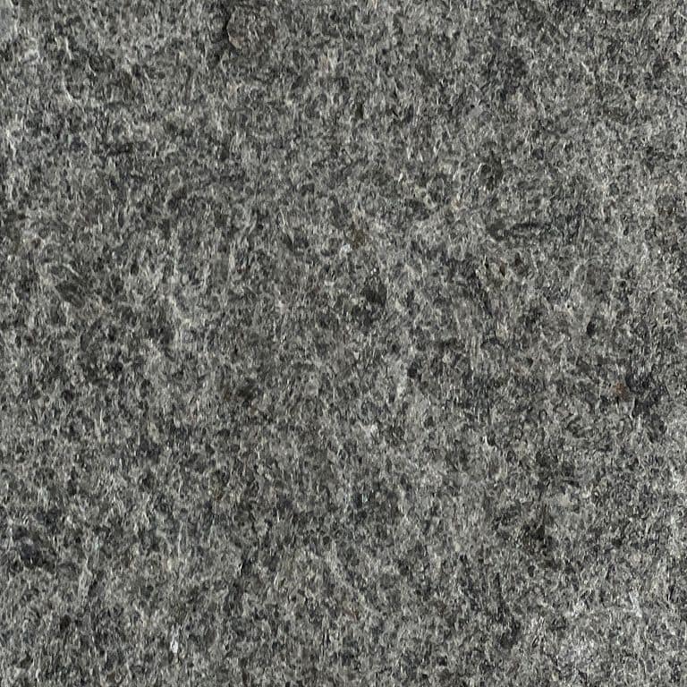 Feature image for Groton Black Granite. The surface finish shown is flamed. The dominant color shown is gray; with brown, green and purple secondaries. The color mix creates a cool feeling. Speckled and random color patterns. Contains some mica.