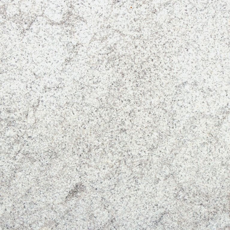 Feature image for Ocean Blue® Marble. The surface finish shown is sand blasted. Dominant colors shown are gray and cream. The color mix creates a cool feeling. Fine speckled and cloudy color patterns.