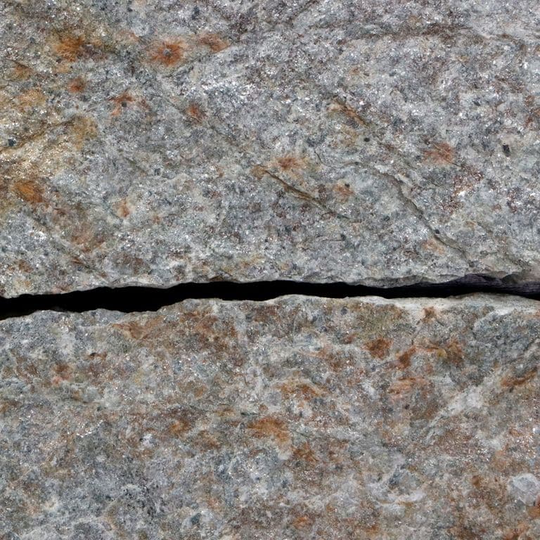 Best close-up image for Quaker Hill Gray Granite. The surface finish shown is . The dominant color shown is gray. The color mix creates a warm feeling. Regular and cloudy color patterns. Contains some mica.