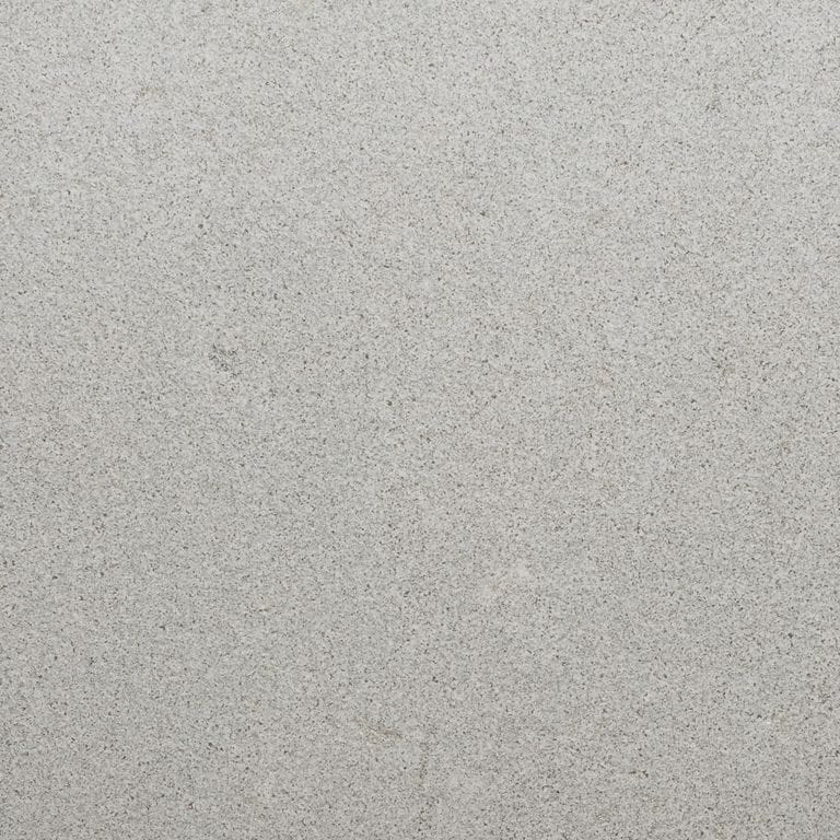 Color/Finish variation image for Northern Bay Limestone. The surface finish shown is sand blasted. Dominant colors shown are beige and gray. The color mix creates a cool feeling. Fine speckled color pattern.
