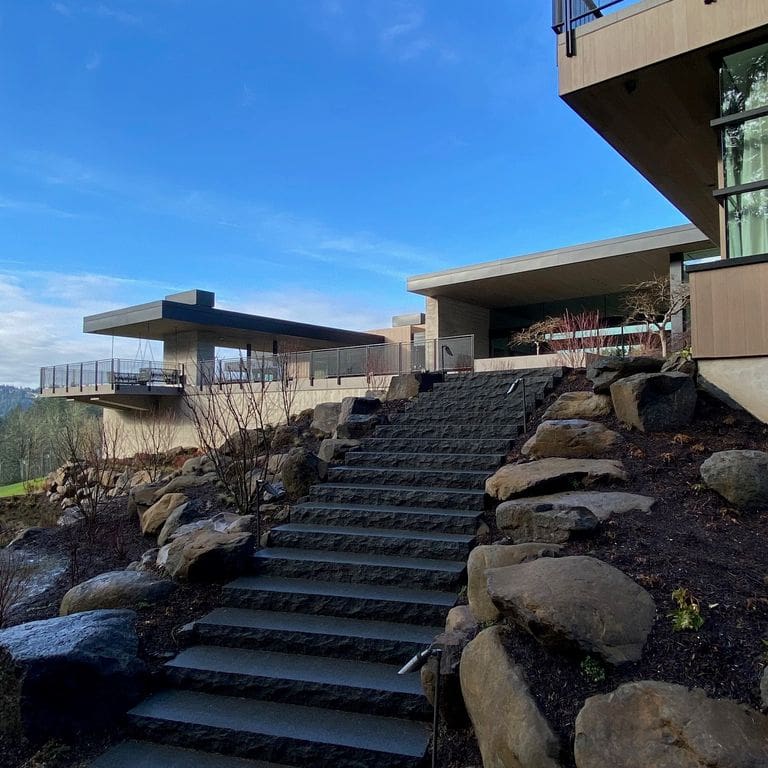 Feature image for Granite - Pensy Black. The image shows this material being used for path pavers and monolithic steps. Dominant colors shown are black and gray. The color mix creates a cool feeling.