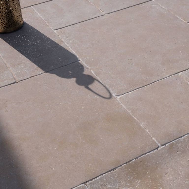 Best close-up image for Limestone - Meknes Beige. The image shows this material being used for pool coping and pool deck pavers. The surface finish shown is antiqued. Dominant colors shown are beige, brown, gray, orange/rust and tan. The color mix creates a warm feeling.