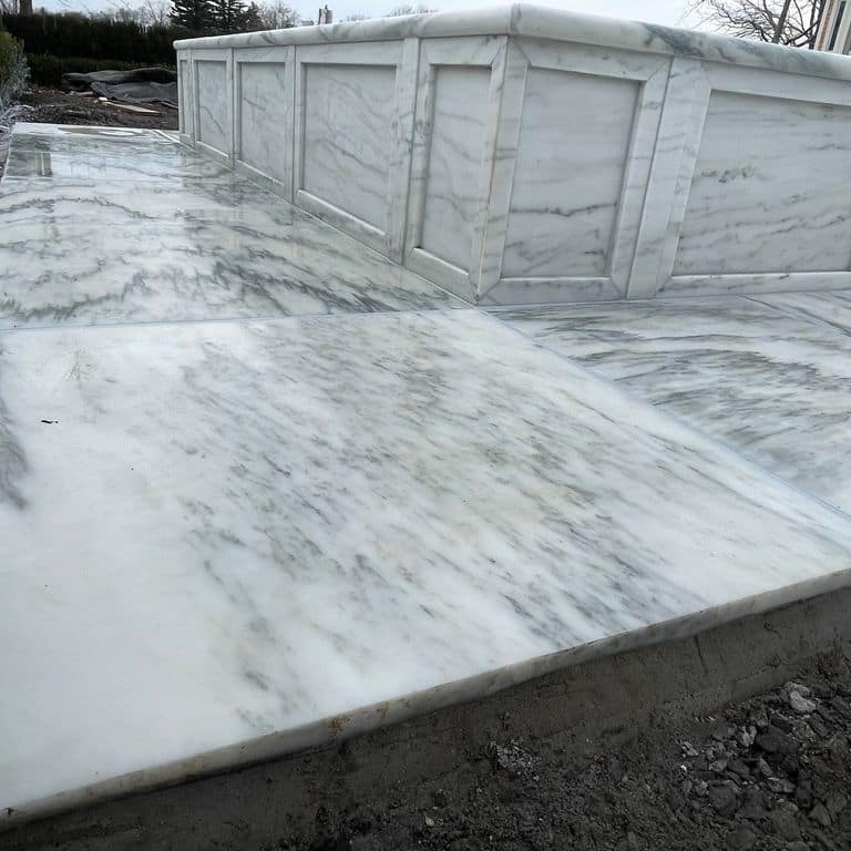 Application image for Marble - White Cloud. The image shows this material being used for pool coping and thin veneer. The dominant color shown is white. The color mix creates a cool feeling.