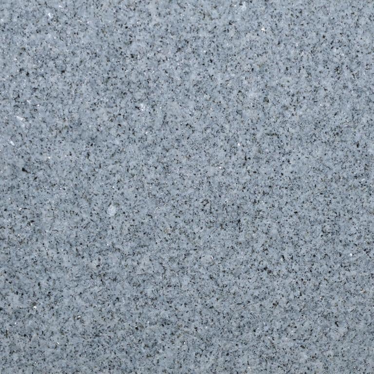 Feature image for Granite - Oak Hill Gray. The surface finish shown is flamed. Dominant colors shown are gray and white; with beige, orange/rust and purple secondaries. Exhibits "movement" and the color mix creates a cool feeling. Speckled color pattern. Contains mineral inclusions.
