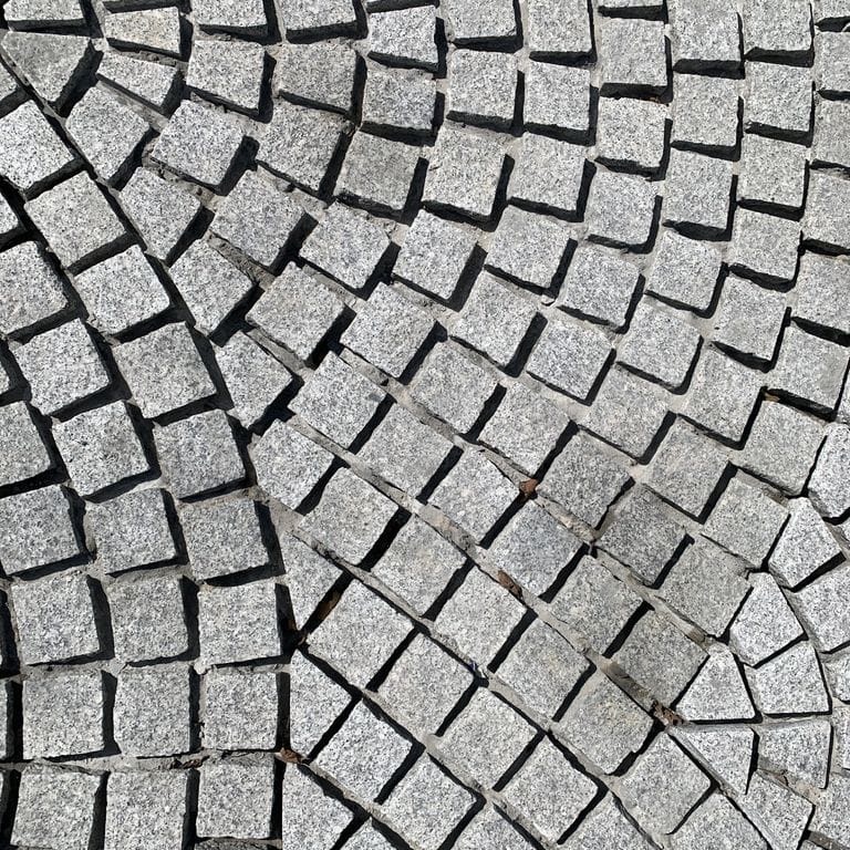 Application image for Superior Snow Granite. The image shows this material being used in a path pavers application. Dominant colors shown are gray and white.