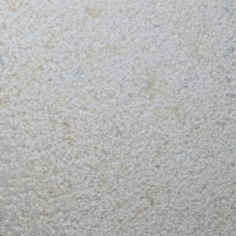 Color/Finish variation image for Dovewhite Limestone. The surface finish shown is bush hammered. Dominant colors shown are gray and white. The color mix creates a cool feeling.