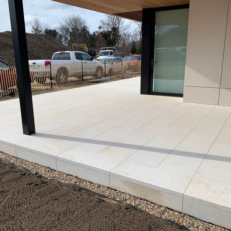 Application image for Buff Limestone. The image shows this material being used in a patio pavers application. The surface finish shown is sand blasted. Dominant colors shown are beige and tan. The color mix creates a warm feeling.