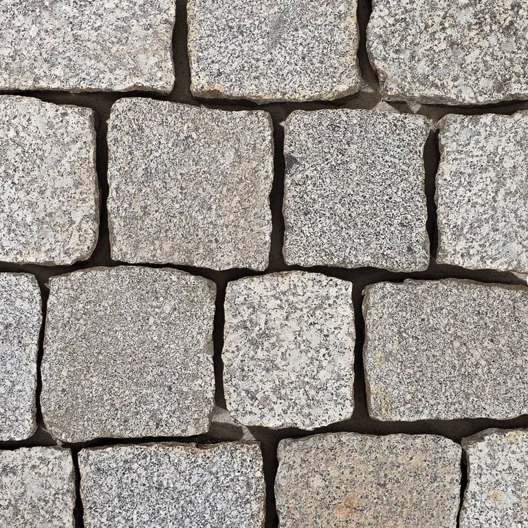Color/Finish variation image for Reclaimed Berlin Granite Cobblestones. The surface finish shown is flamed. The dominant color shown is gray. The color mix creates a warm feeling.