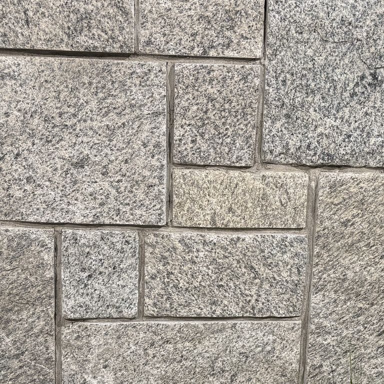 Color/Finish variation image for Tower Hill Granite. The surface finish shown is split-face. The dominant color shown is gray. The color mix creates a warm feeling. Speckled and coarse speckled color patterns.