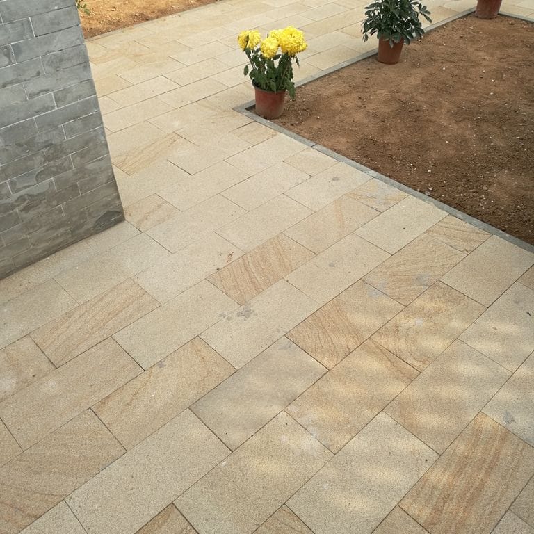 Application image for Beige Vein Cut Granite. The image shows this material being used in a path pavers application. Dominant colors shown are orange/rust and tan. The color mix creates a warm feeling.