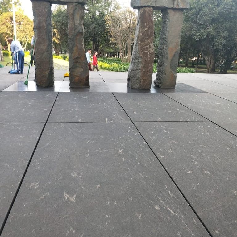 Application image for Strata Mist Cross-Cut Gneiss. The image shows this material being used for patio pavers and public area. The dominant color shown is gray. The color mix creates a cool feeling.