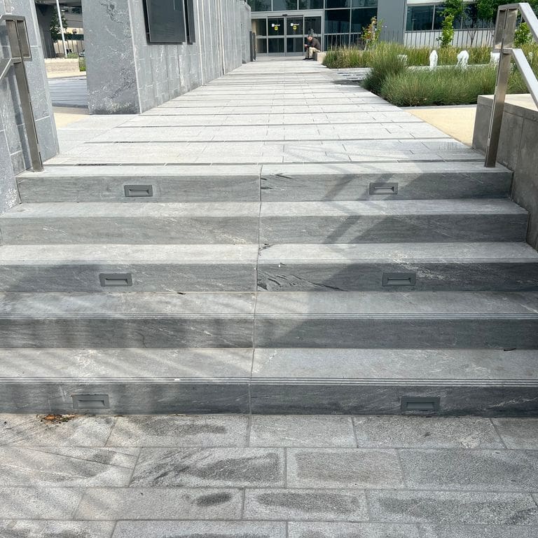 Application image for Strata Mist Cross-Cut Gneiss. The image shows this material being used for landings, monolithic steps and treads. The dominant color shown is gray. The color mix creates a cool feeling.