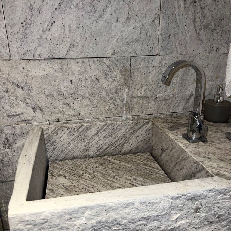 Application image for Strata Snow Gneiss. The image shows this material being used in an interior cladding application. The surface finish shown is split-face. The dominant color shown is white.