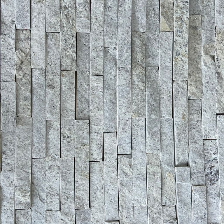 Application image for Strata Snow Gneiss. The image shows this material being used in an interior cladding application. The surface finish shown is split-face. Dominant colors shown are gray and white. The color mix creates a cool feeling.
