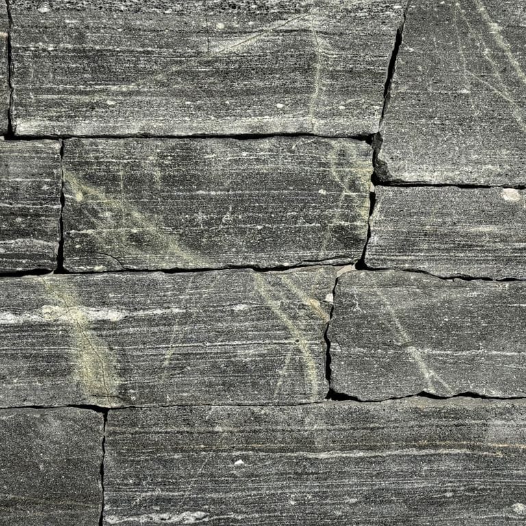 Color/Finish variation image for Greenwich Gray Granite. The surface finish shown is split-face. Dominant colors shown are green and gray. The color mix creates a cool feeling.