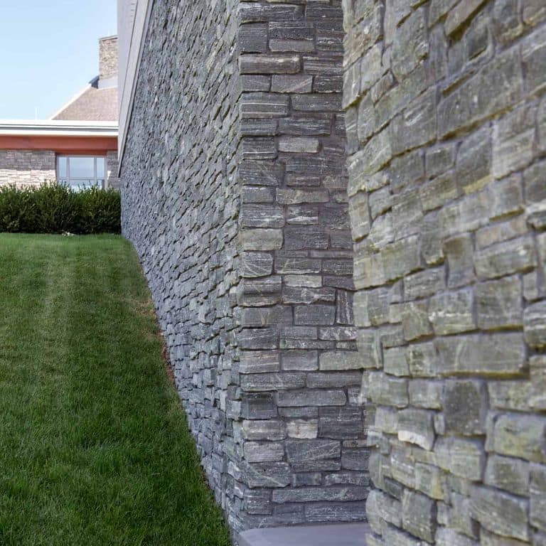 Application image for Greenwich Gray Granite. The image shows this material being used in a thin veneer application. The surface finish shown is split-face. The dominant color shown is gray. The color mix creates a cool feeling.