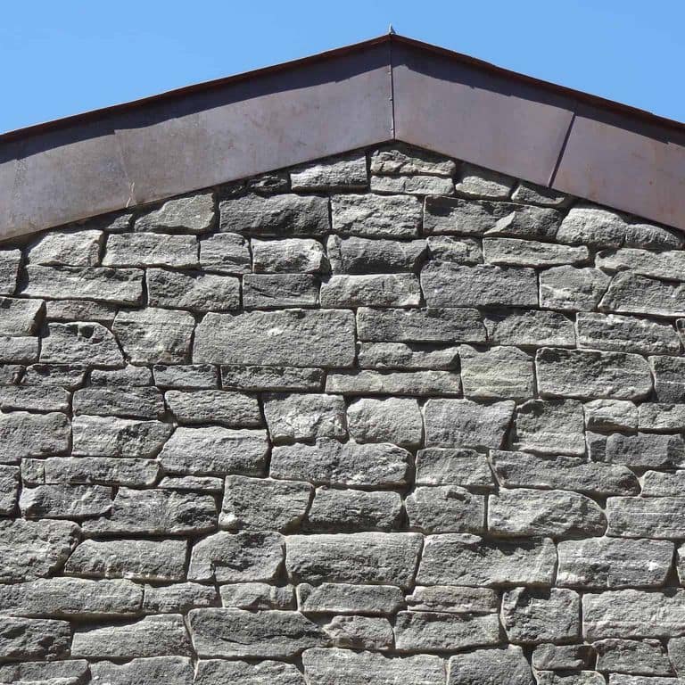 Application image for Greenwich Gray Granite. The image shows this material being used in a thin veneer application. The surface finish shown is split-face. The dominant color shown is gray. The color mix creates a cool feeling.
