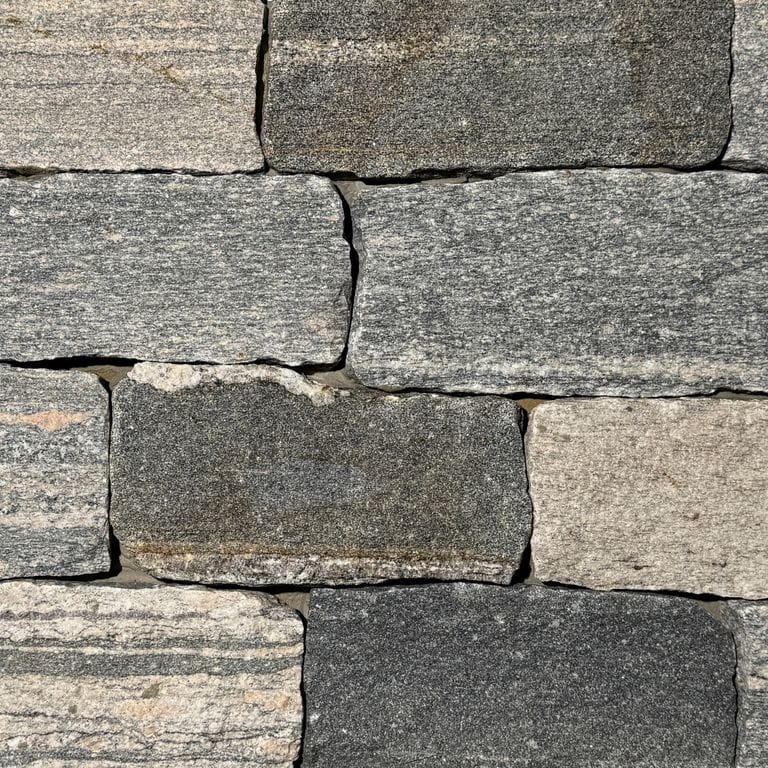 Color/Finish variation image for Mystic Harbor Granite. The surface finish shown is split-face. The dominant color shown is gray. The color mix creates a warm feeling.