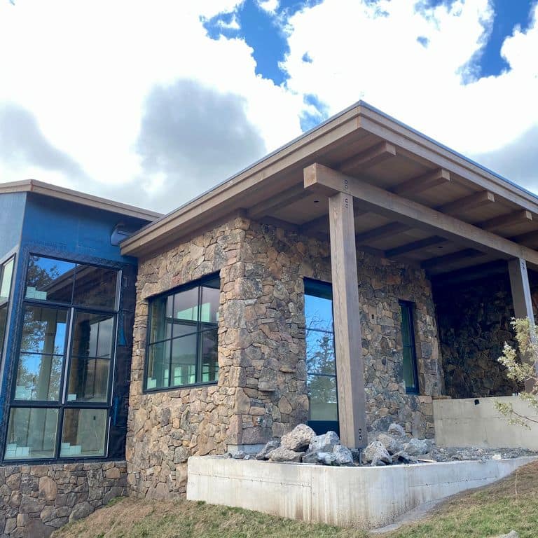 Application image for Montana Moss Rock. The image shows this material being used in a full bed veneer application. The dominant color shown is gray. The color mix creates a warm feeling.