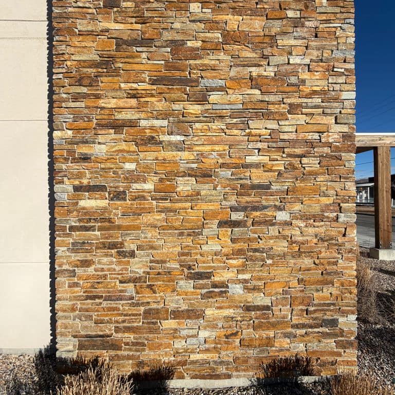 Application image for Oakley Stone - Gold. The image shows this material being used in a full bed veneer application. The surface finish shown is split-face. Dominant colors shown are brown and orange/rust. The color mix creates a warm feeling.