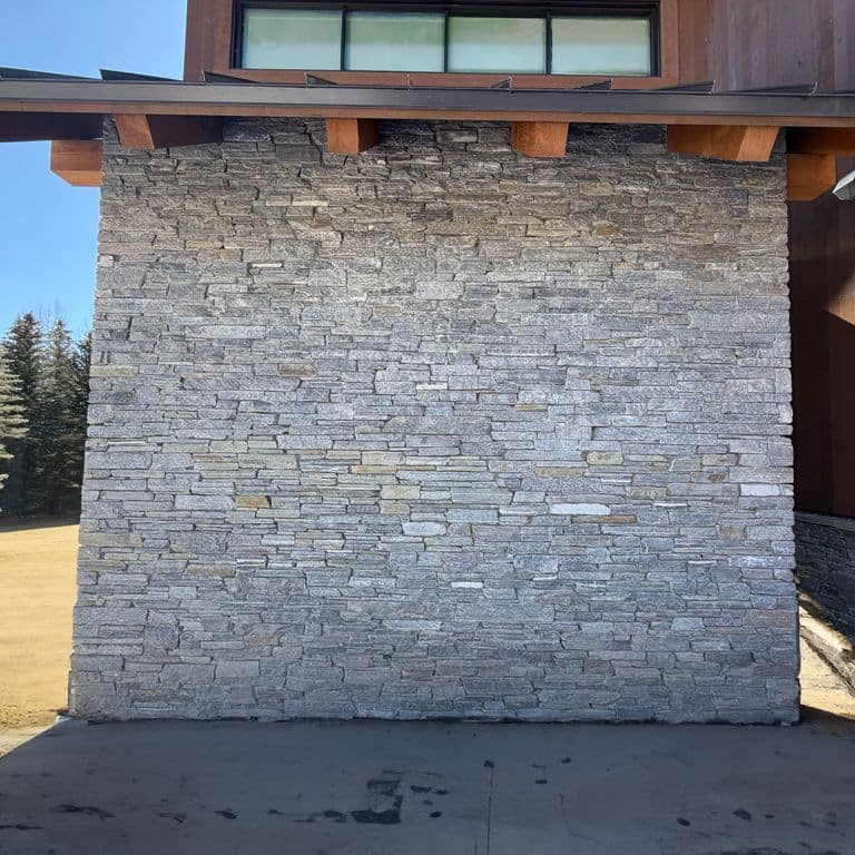 Application image for Charcoal Oakley Stone. The image shows this material being used in a full bed veneer application. The surface finish shown is split-face. The dominant color shown is gray.