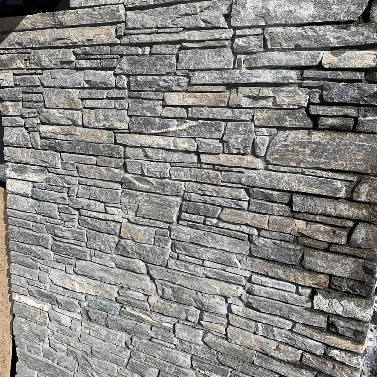 Application image for Charcoal Oakley Stone. The image shows this material being used for full bed veneer and thin veneer. The surface finish shown is split-face. The dominant color shown is gray. The color mix creates a cool feeling.