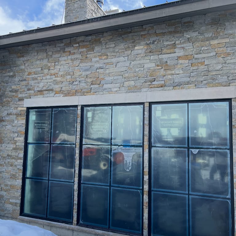 Application image for Oakley Stone - Birch Silver. The image shows this material being used in a full bed veneer application. The surface finish shown is split-face. Dominant colors shown are beige and gray. The color mix creates a cool feeling.