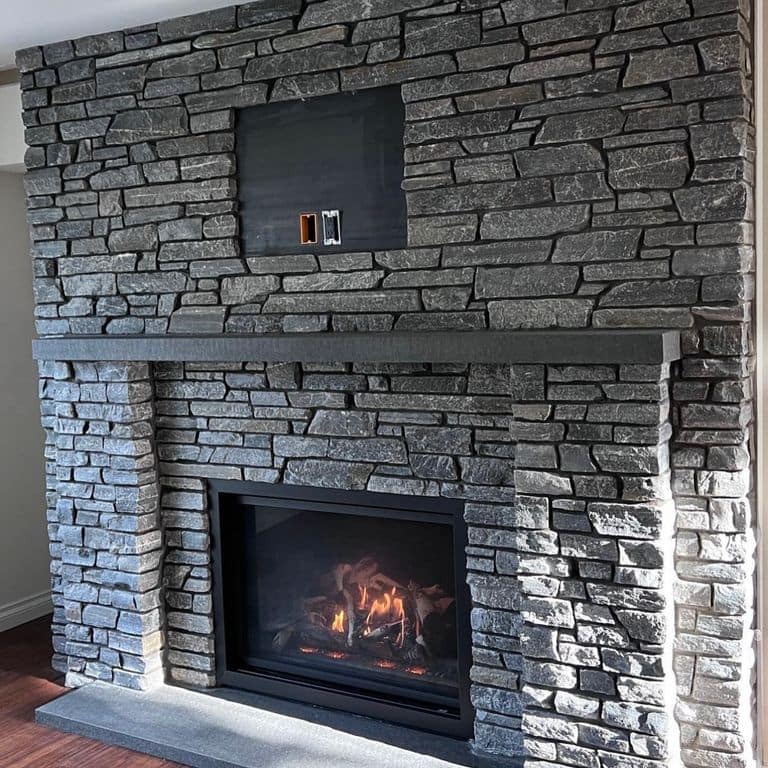 Application image for Cowboy Coffee Quartzite. The image shows this material being used for full bed veneer and thin veneer. The surface finish shown is split-face. The dominant color shown is gray. The color mix creates a cool feeling.
