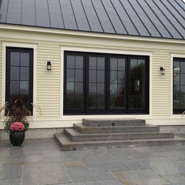 Application image for Oak Mountain Granite. The image shows this material being used for patio pavers and monolithic steps. The surface finish shown is flamed. The dominant color shown is gray. The color mix creates a warm feeling. Regular color pattern. Contains mineral inclusions.