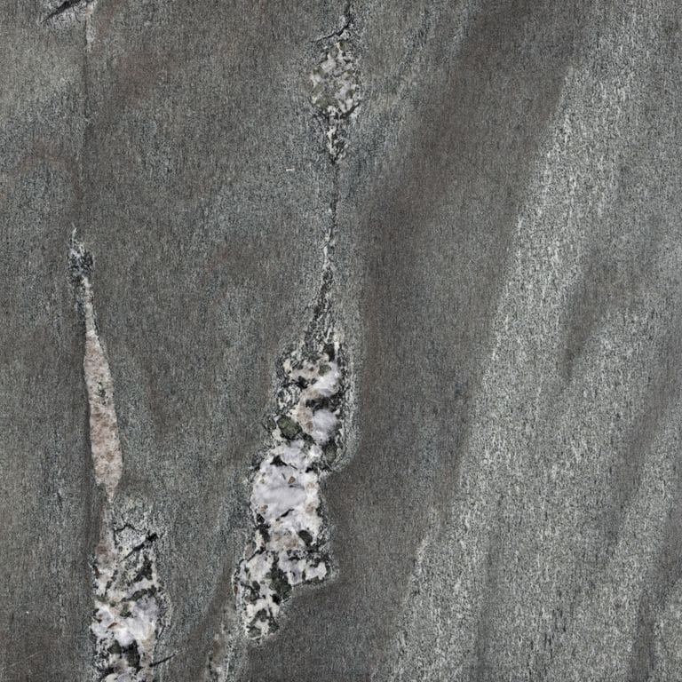 Color/Finish variation image for Granite - Mystic Mountain- Flamed. The surface finish shown is polished. Dominant colors shown are green and gray; with black, brown, purple and white secondaries. Exhibits "movement" and the color mix creates a cool feeling. Streaked and marbled color patterns.