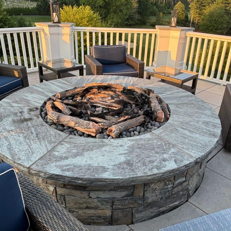 Application image for Mystic Mountain Granite - Flamed. The image shows this material being used in a wallstone cap application. The surface finish shown is flamed. The dominant color shown is gray. Exhibits "movement" and the color mix creates a cool feeling.