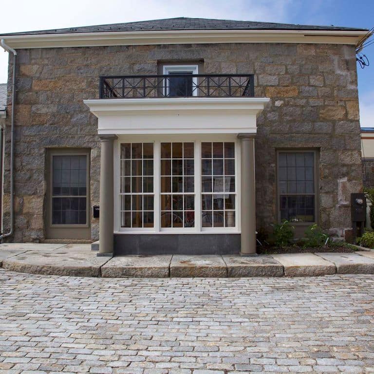 Application image for Granite - Reclaimed New England Cobblestones. The image shows this material being used in a driveway pavers application.
