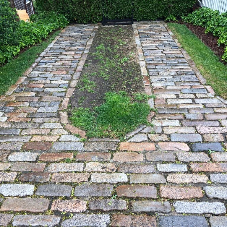 The image shows this material being used in a driveway pavers application.