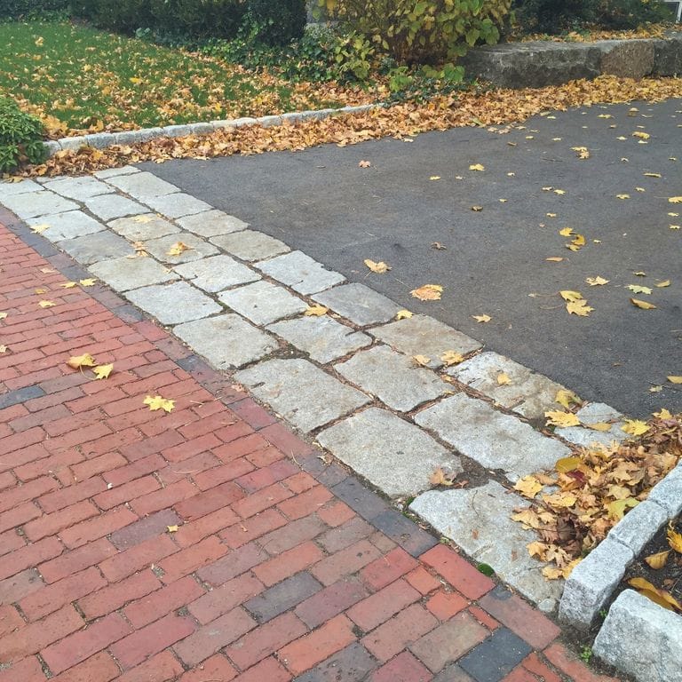 The image shows this material being used in a driveway aprons application. The dominant color shown is gray.