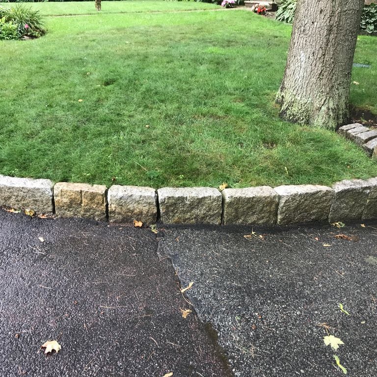 Application image for Reclaimed New England Granite Cobblestones - Super Jumbo. The image shows this material being used in a landscape curbing &amp; edging application. This is a landscape stone for outdoor commercial and residential applications. Suitable for general use, freeze-thaw conditions, low heat absorption surfaces, high traffic areas and low slipperiness surfaces situations. Moderate to higher on the price spectrum.