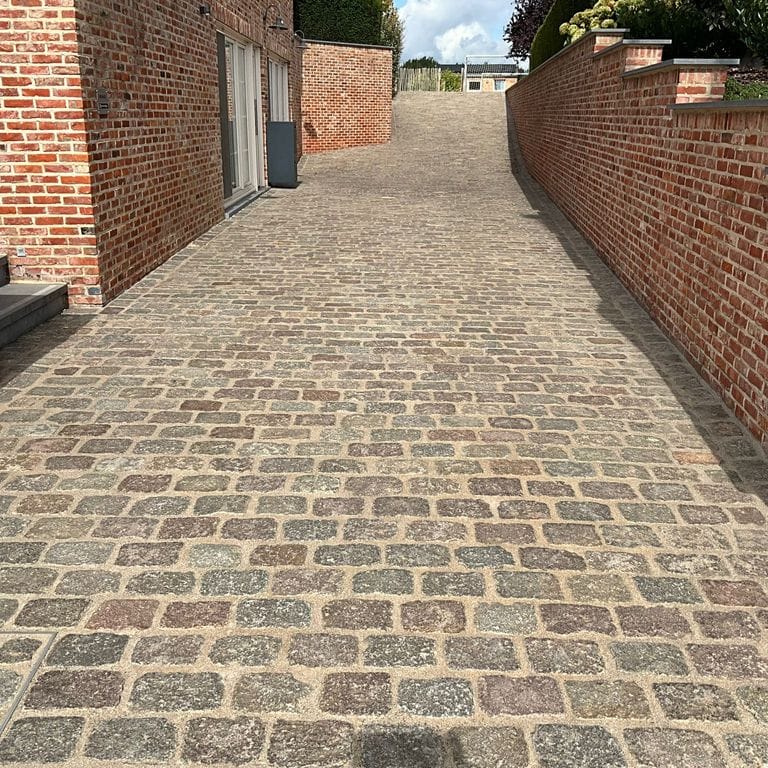 Application image for Reclaimed Swedish Granite Cobblestones. The image shows this material being used for path pavers and public area. The surface finish shown is . Dominant colors shown are brown and tan. The color mix creates a warm feeling.