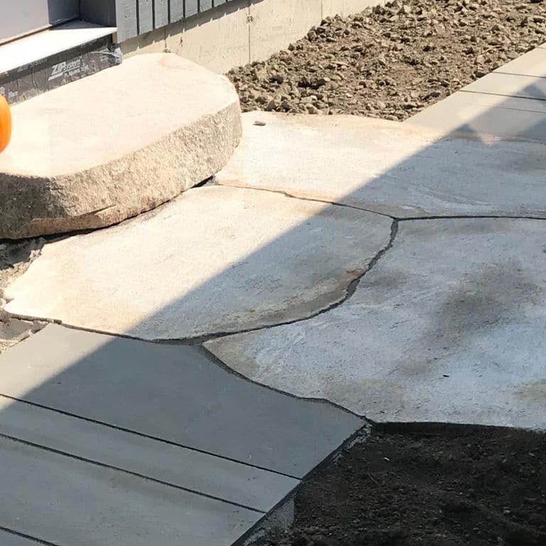 Application image for New England Fieldstone Boulders &amp; Ledgestone. The image shows this material being used for path pavers and landings. The surface finish shown is weathered. The dominant color shown is gray. The color mix creates a cool feeling.