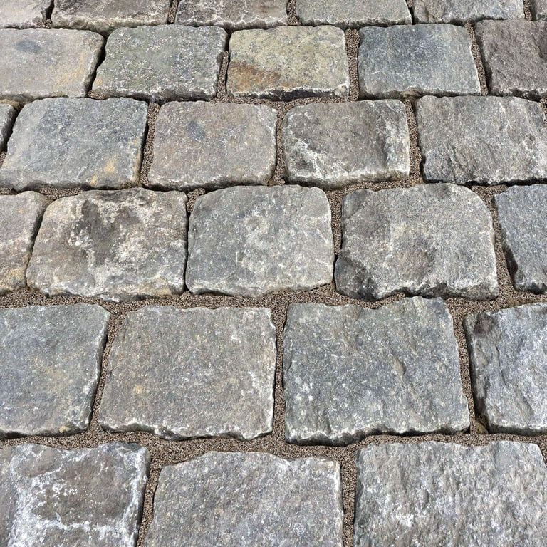 Application image for Reclaimed European Porphyry Cobblestones. The surface finish shown is . The dominant color shown is gray; with beige, black, blue, brown, green, purple, white, tan and cream secondaries. The color mix creates a warm feeling. Speckled and blotched color patterns.