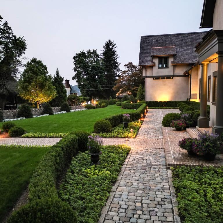 Application image for Reclaimed European Sandstone Cobblestones. The image shows this material being used in a path pavers application. The surface finish shown is . Dominant colors shown are gray and tan.