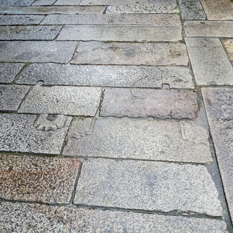 Application image for Reclaimed Footworn Granite Planks. The image shows this material being used in a path pavers application. The dominant color shown is gray. The color mix creates a warm feeling.