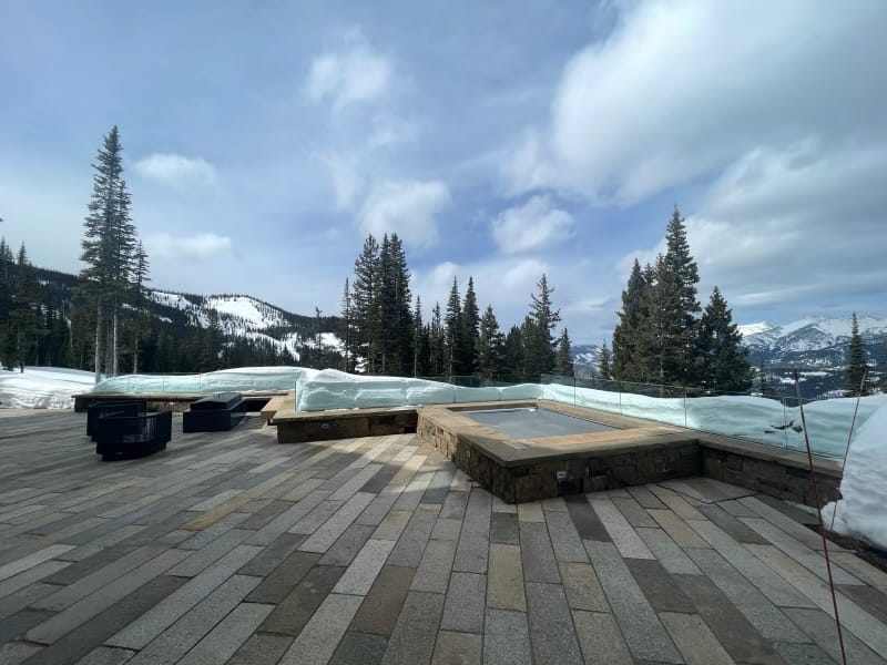 Application image for Reclaimed Footworn Granite Planks. The image shows this material being used in a patio pavers application. The surface finish shown is . Dominant colors shown are gray and tan. The color mix creates a warm feeling.