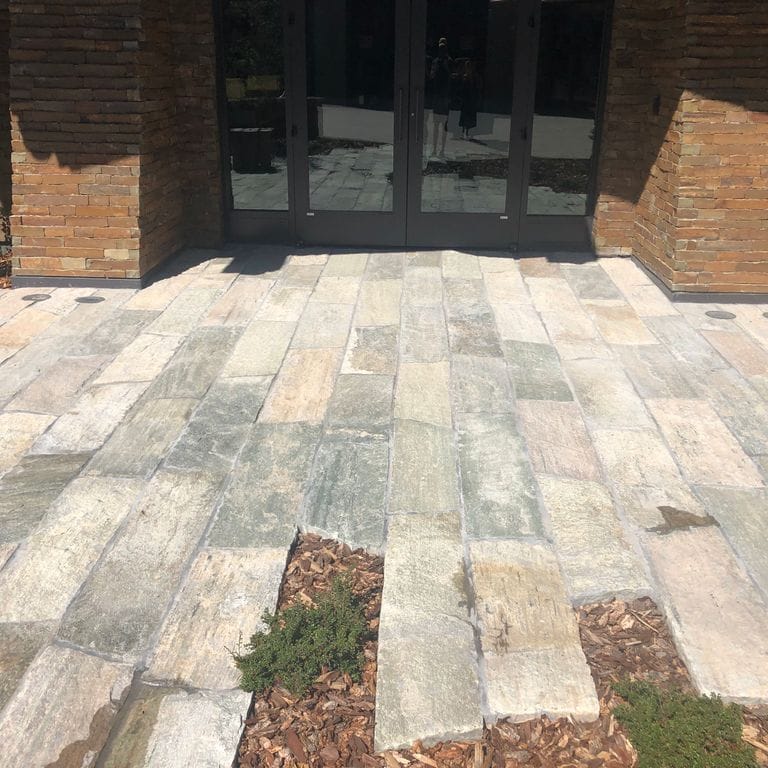 The image shows this material being used in a patio pavers application. Dominant colors shown are beige and tan; with brown, gray, white and cream secondaries. The color mix creates a warm feeling. Regular and streaked color patterns.