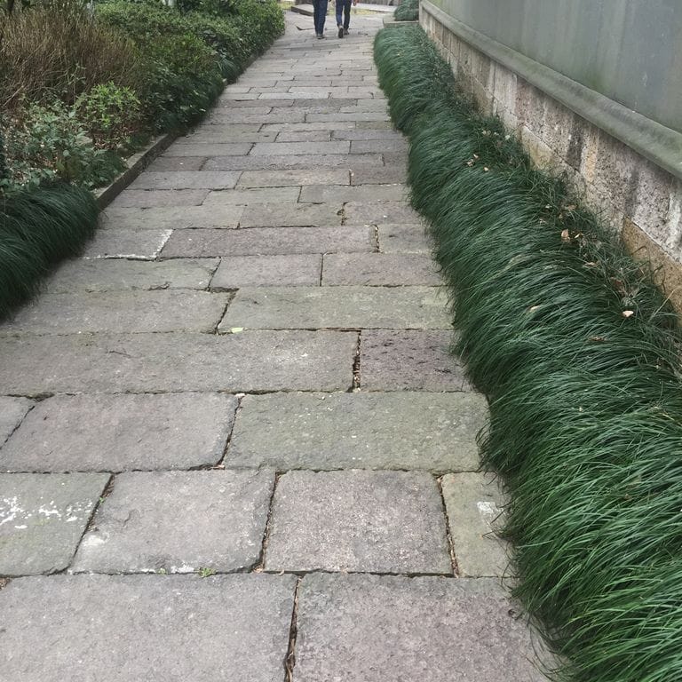The image shows this material being used in a path pavers application. The dominant color shown is gray. The color mix creates a cool feeling. Regular and fine speckled color patterns.