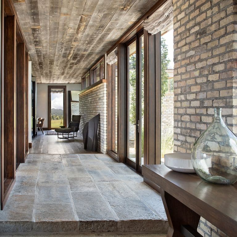 Feature image for Reclaimed Highland Limestone Plank Pavers. The image shows this material being used in an interior floor application. Dominant colors shown are gray and tan; with beige, pink, purple, white, tan and cream secondaries. Exhibits "movement" and the color mix creates a warm feeling. Speckled, blotched, random and cloudy color patterns.